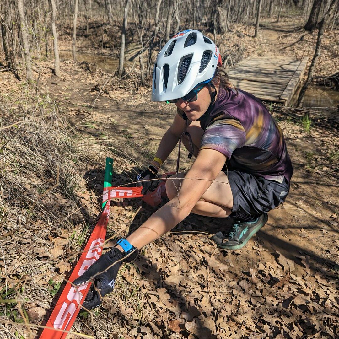 Volunteer putting down mountain bike race tape